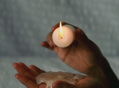 Close-up of hands in a meditative mudra gesture with soft lighting.